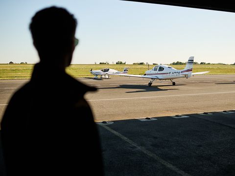 AFA - Cadet from behind looking at an aircraft Cadet seen from behind looking at a Cirrus SR20 Airbus Flight Academy aircraft on sunny Angoulême's airport tarmac