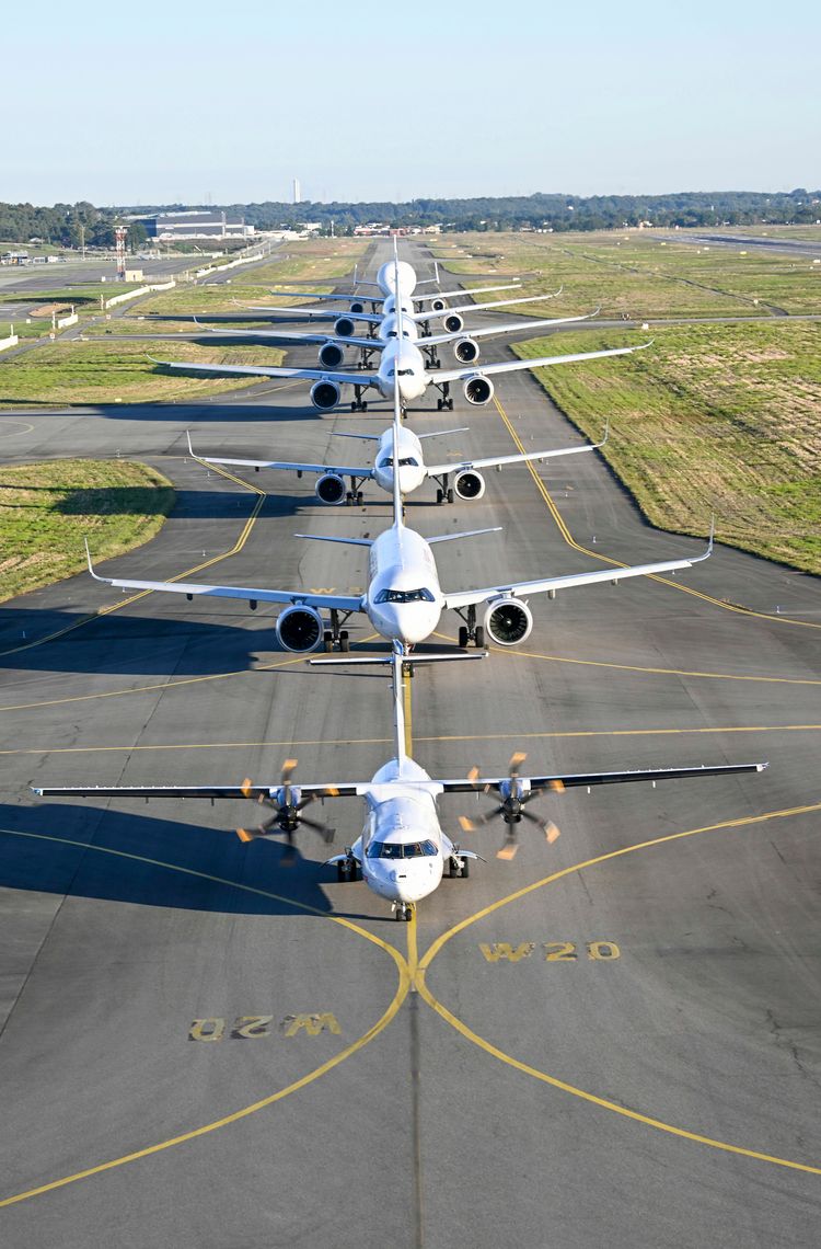 Airbus Family Flight Elevated view of Airbus aircraft, including A320, A330, and A350, lined up on the tarmac for a Family Day event.