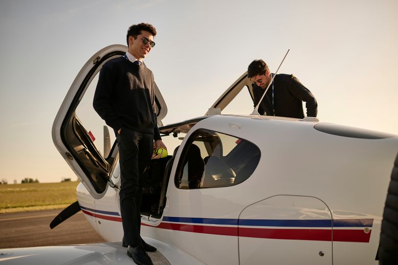 AFA - Two cadets beside an aircraft Two cadets on the wings of an Airbus Flight Academy aircraft in the sun, preparing to go in the aircraft