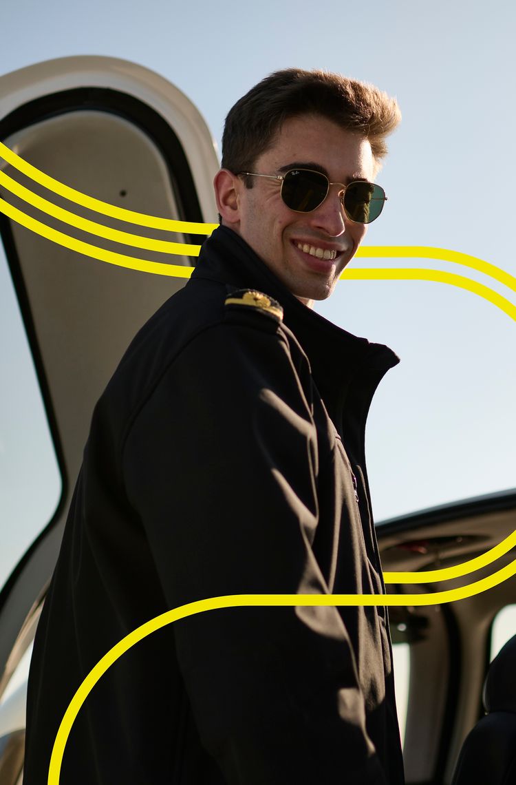AFA - Cadet smiling by an aircraft 1 with stripes Smiling cadet on the wing of a Cirrus SR20 Airbus Flight Academy aircraft on sunny Angoulême's airport tarmac