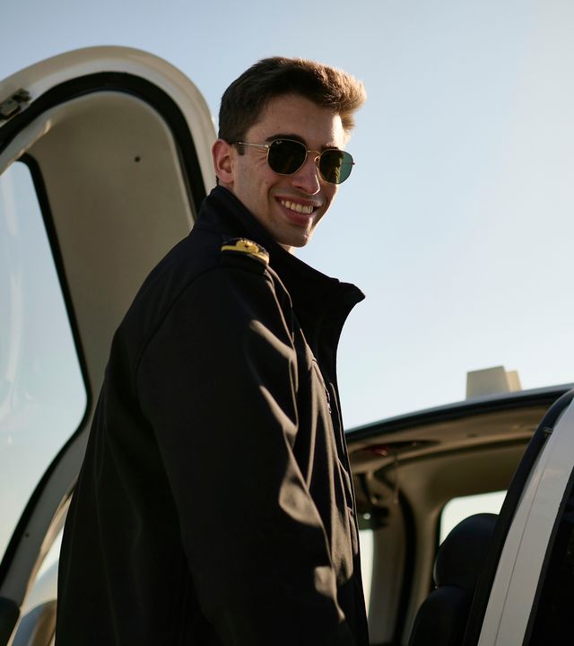 AFA - Cadet smiling by an aircraft 1 Smiling cadet on the wing of a Cirrus SR20 Airbus Flight Academy aircraft on sunny Angoulême's airport tarmac